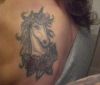 unicorn head tattoo on left shoulder blade