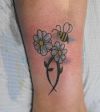 bee flying on flower leg tattoo