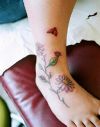 ladybug and flower tattoos on leg