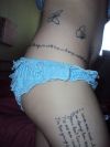 butterfly and text tattoo on thigh and stomach