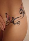 butterfly and tribal image tattoo on hip