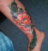 peacock feather and lotus tattoos on leg