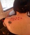 dandelion flower blow tattoo on back of women