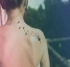 dandelion flower tattoo on back of girl