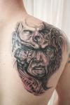 demon face tattoo on right shoulder blade