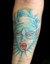 blue vampire face tattoo on arm
