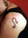 red leo sign tattoo on shoulder