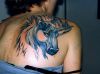 unicorn tattoo on right shoulder blade