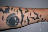 bat and skull tattoo on arm
