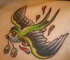 flying bird with small skull tattoo