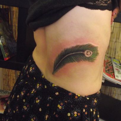 Peacock Feather Tattoo On Rib Of Girl