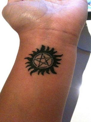Pentagram And Sun Tattoo On Wrist