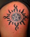 pentagram and sun tattoo on arm