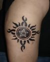 pentagram and sun tattoo on arm